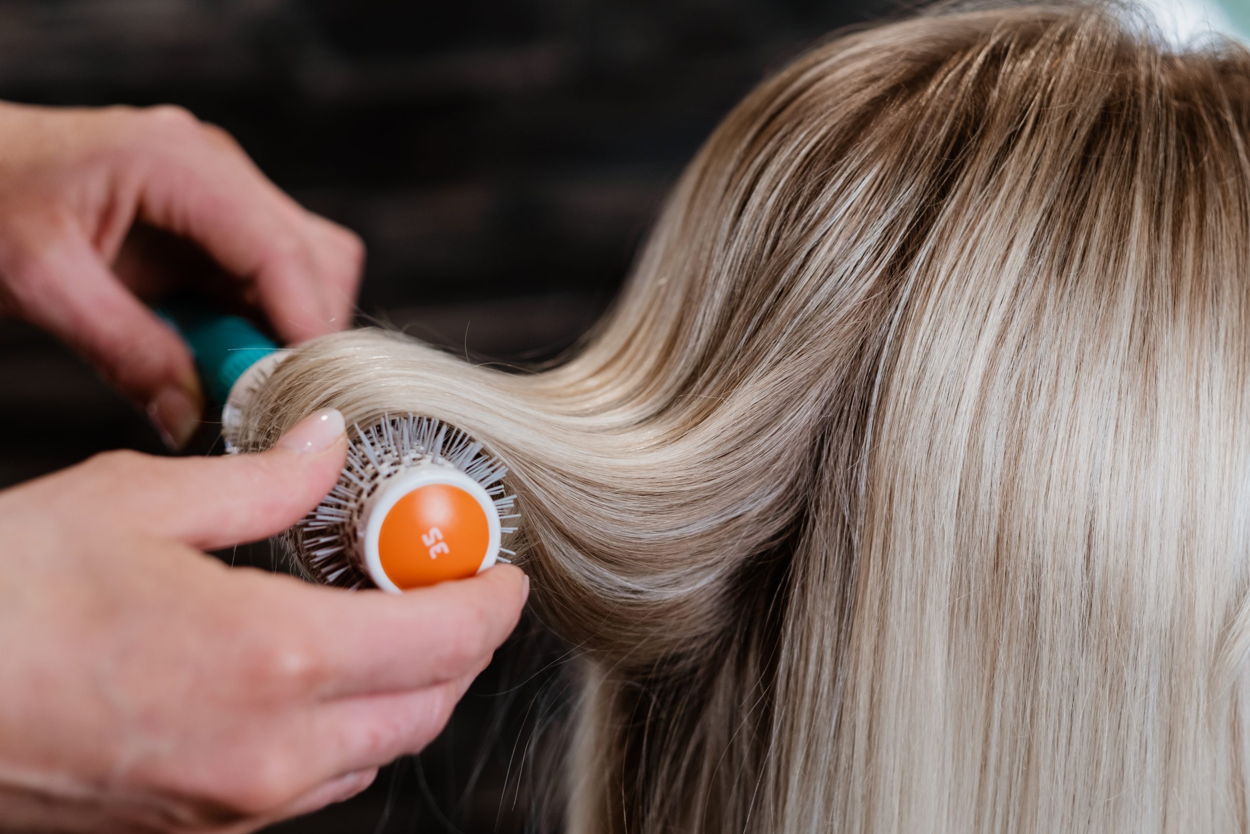 Sfeerafbeelding: close-up van blonde haren die worden geborsteld.